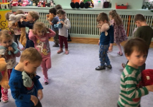Grupa dzieci najmłodszych podczas zabaw z okazji Dnia Pluszowego Misia.