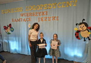 Nauczycielka i dwie dziewczynki biorące udział w konkursie recytatorskim